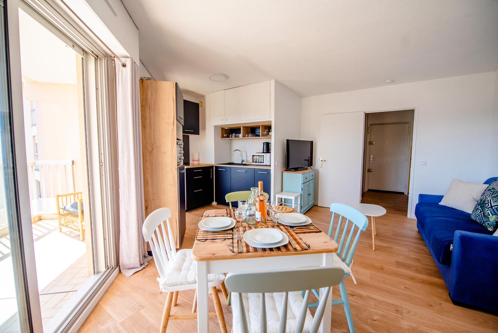 Dans cet appartement du bord de mer, destiné à la location de vacances, nous avons repensé la décoration afin de créer une atmosphère plus chaleureuse et accueillante.
Nous avons remplacé l’ancien carrelage un peu vieillot par un joli parquet aux teintes chaudes.
Les murs et le plafond ont été repeints en blanc chaud afin d’éclaircir la pièce, qui est déjà baignée de lumière.
Certains meubles comme la table à manger, les chaises et le buffet, ont été conservés afin de réduire le budget mobilier, mais ils ont été poncés et repeints afin de leur donner une nouvelle jeunesse. En revanche, le canapé et la table basse ont été achetés neufs.
Un peu de décoration a été ajoutée afin d’ajouter un aspect cocooning au lieu.