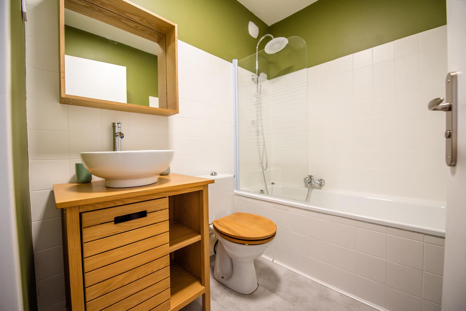 Dans cet appartement du bord de mer, destiné à la location de vacances, nous avons repensé la décoration afin de créer une atmosphère plus chaleureuse et accueillante.
Nous avons remplacé l’ancien carrelage un peu vieillot par un joli parquet aux teintes chaudes.
Les murs et le plafond ont été repeints en blanc chaud afin d’éclaircir la pièce, qui est déjà baignée de lumière.
Certains meubles comme la table à manger, les chaises et le buffet, ont été conservés afin de réduire le budget mobilier, mais ils ont été poncés et repeints afin de leur donner une nouvelle jeunesse. En revanche, le canapé et la table basse ont été achetés neufs.
Un peu de décoration a été ajoutée afin d’ajouter un aspect cocooning au lieu.